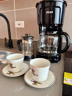 two cups on plates on a counter with a coffee maker at Lujoso y cómodo Loft en Laureles in Medellín