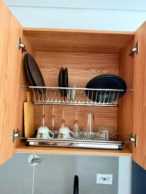 a cabinet with plates and utensils in it at Lujoso y cómodo Loft en Laureles in Medellín