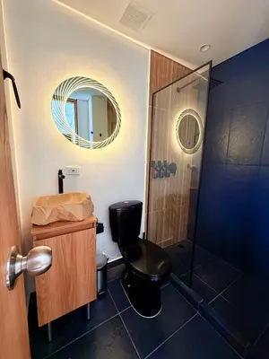 a bathroom with a black toilet and a mirror at Lujoso y cómodo Loft en Laureles in Medellín