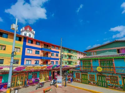 a group of buildings with umbrellas on a street at La Jaus by Hope in Guatapé