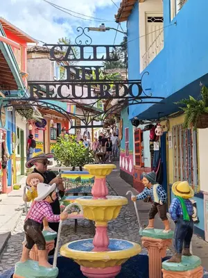 a group of figurines standing around a fountain on a street at La Jaus by Hope in Guatapé