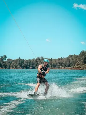 a man is water skiing on a body of water at La Jaus by Hope in Guatapé