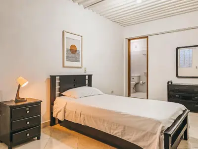 a bedroom with a bed and a dresser with a lamp at La Jaus by Hope in Guatapé