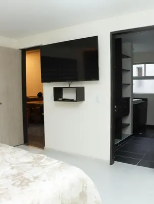 a bedroom with a flat screen tv on a wall at Relax Medellín 10ppl 3br 4b Jacuzzi 2,075 sq ft in Medellín