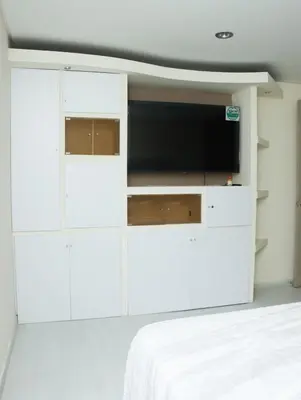 a bedroom with white cabinets and a flat screen tv at Relax Medellín 10ppl 3br 4b Jacuzzi 2,075 sq ft in Medellín