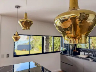 a kitchen with a large gold fixture hanging from the ceiling at masion la catedral de pablo con vista a la montaña in Envigado
