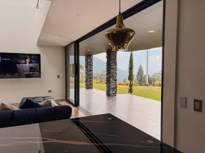 a living room with a couch and a large glass window at masion la catedral de pablo con vista a la montaña in Envigado