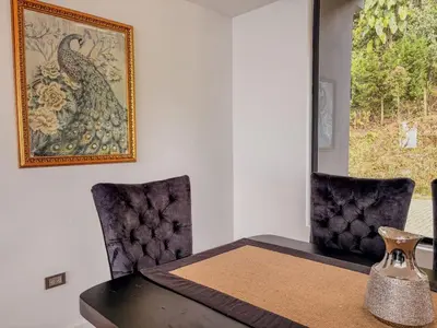 a dining room with a table and a picture of a peacock at masion la catedral de pablo con vista a la montaña in Envigado