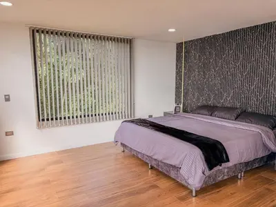 a bedroom with a bed and a large window at masion la catedral de pablo con vista a la montaña in Envigado