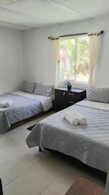 a bedroom with two beds and a window at El Palmar Lodge in Chiquinquirá