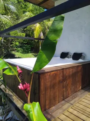 a wooden deck with a bed and a plant at El Palmar Lodge in Chiquinquirá