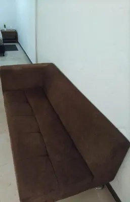 a brown couch sitting in the corner of a room at El Palmar Lodge in Chiquinquirá