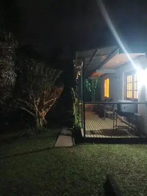 a house with a porch at night with lights at El Palmar Lodge in Chiquinquirá