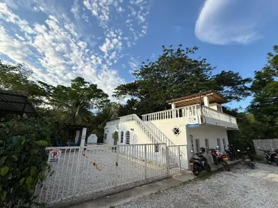 a white house with two motorcycles parked in front of it at Cabañas Milos in Doradal