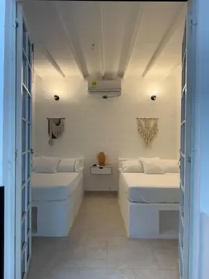 two beds in a room with two windows at Cabañas Milos in Doradal