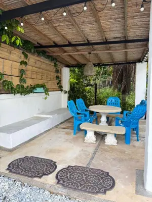 a patio with blue chairs and a table at Cabañas Milos in Doradal