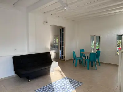 a living room with a black couch and a table at Cabañas Milos in Doradal