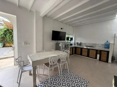 a kitchen with a table and chairs in a room at Cabañas Milos in Doradal