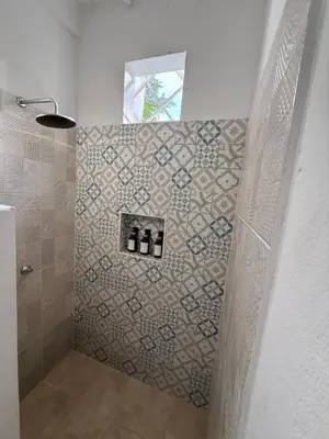 a bathroom with a shower with three bottles on a wall at Cabañas Milos in Doradal