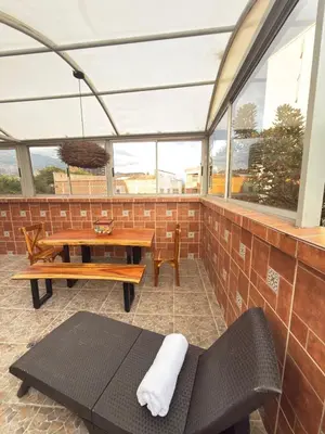 a screened in porch with a table and benches at SkyView Medellín 4ppl 1br 1b luxury terrace loft in Medellín
