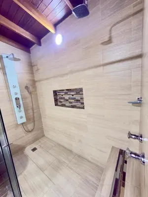 a bathroom with a shower with a wall at SkyView Medellín 4ppl 1br 1b luxury terrace loft in Medellín