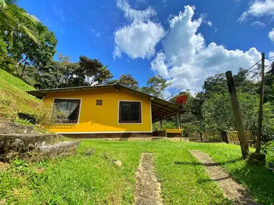 a yellow house on a hill with a green yard at Casa del Río San Rafael in San Rafael