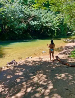 a woman in a bikini standing on the shore of a river at Casa del Río San Rafael in San Rafael
