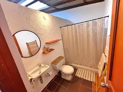 a bathroom with a toilet and a sink and a mirror at Casa del Río San Rafael in San Rafael