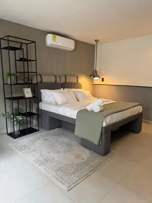 a bedroom with a large bed and a shelf at Poblado Walkable Loft - Parking Included in Medellín