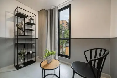 a living room with a chair and a table and a window at Poblado Walkable Loft - Parking Included in Medellín