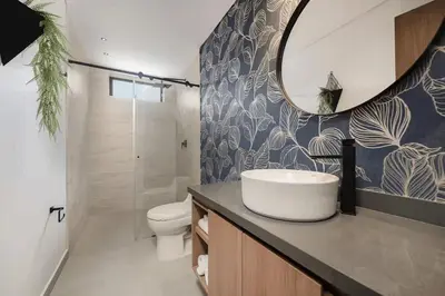 a bathroom with a sink and a toilet and a mirror at Poblado Walkable Loft - Parking Included in Medellín