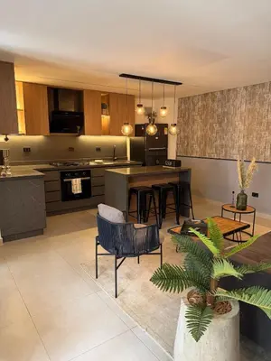 a kitchen and living room with a table and chairs at Poblado Walkable Loft - Parking Included in Medellín