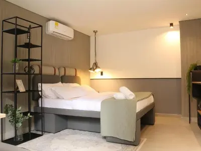 a bedroom with a large bed with a black and white bed sqor at Poblado Walkable Loft - Parking Included in Medellín