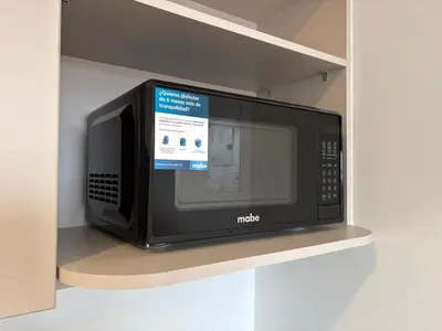 a microwave oven sitting on a shelf in a kitchen at Apartamento Laureles in Medellín