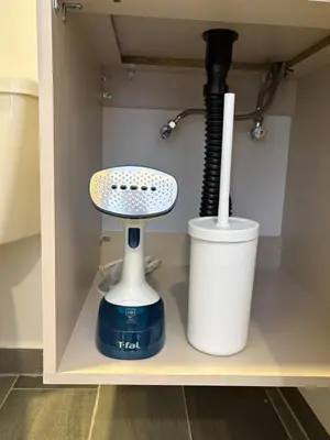 a hair dryer and a whisk in a cabinet at Apartamento Laureles in Medellín