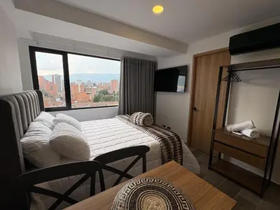 a hotel room with a bed and a large window at Apartamento Laureles in Medellín