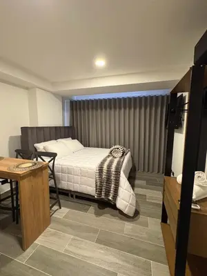 a bedroom with a bed and a table in a room at Apartamento Laureles in Medellín