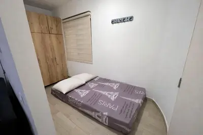 a small bedroom with a bed and a closet at Loft con balcón y baño Laureles Belén TOP LOCATION in Medellín