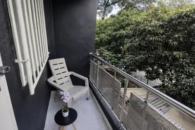 a white chair sitting on a balcony with a plant at Loft con balcón y baño Laureles Belén TOP LOCATION in Medellín