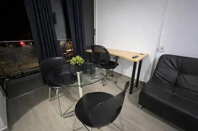 a room with a table and chairs and a couch at Loft con balcón y baño Laureles Belén TOP LOCATION in Medellín