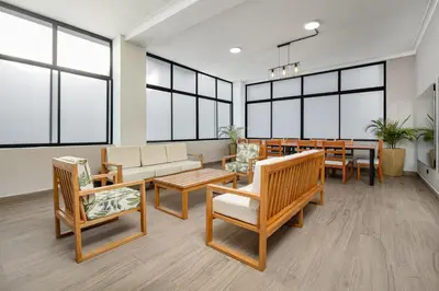a waiting room with chairs and tables and windows at villa poblado in Medellín