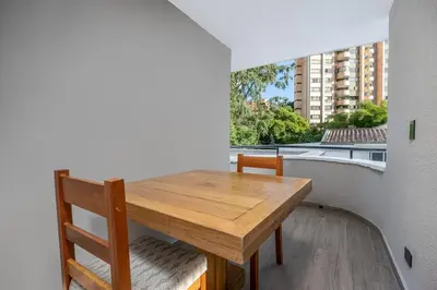 a wooden table and chairs in a room with a window at villa poblado in Medellín