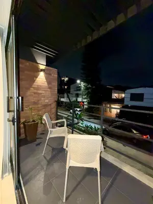 two chairs and a table on a patio at night at Loft lujoso en Laureles in Medellín