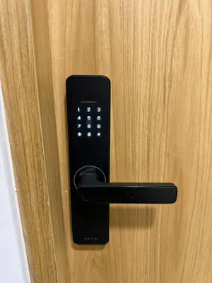 a black remote control on a wooden door at Loft lujoso en Laureles in Medellín