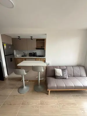 a living room with a couch and a kitchen at Apartamento moderno balcón, Wifi, Netflix-Rionegro in Rionegro