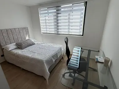 a bedroom with a bed and a glass table and a chair at Apartamento moderno balcón, Wifi, Netflix-Rionegro in Rionegro