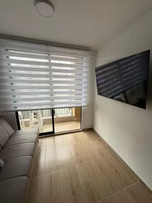 a living room with a couch and a large window at Apartamento moderno balcón, Wifi, Netflix-Rionegro in Rionegro