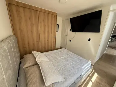 a bedroom with a bed and a flat screen tv at Apartamento moderno balcón, Wifi, Netflix-Rionegro in Rionegro