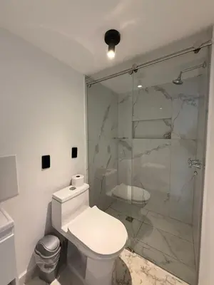 a bathroom with a toilet and a glass shower at Apartamento moderno balcón, Wifi, Netflix-Rionegro in Rionegro
