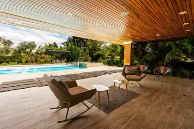a patio with chairs and a swimming pool at Mansión de lujo La Reina Llanogrande in Rionegro